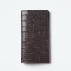 Indulge in timeless elegance with the Ogue Flair Chester Billfold, crafted in a captivating shade of croco brown. This deluxe long billfold is meticulously constructed from premium leather, boasting a flawless, seamless design that emphasizes its sleek silhouette.The Chester Billfold embodies the essence of understated luxury. The rich croco brown leather takes center stage, accentuated by minimal detailing that allows the natural beauty of the material to shine. This focus on clean lines creates a sophisticated aesthetic, perfect for the discerning individual who appreciates quality and style.Beyond its captivating looks, the Chester Billfold prioritizes practicality. The long design ensures a comfortable fit in your coat pocket or bag, while offering ample space for all your essentials. Multiple card slots keep your cards organized and easily accessible, while spacious compartments accommodate your cash and notes.The Ogue Flair Chester Billfold in croco brown is more than just a wallet; it's a sophisticated statement piece that elevates your everyday carry.
