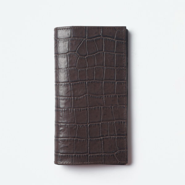 Indulge in timeless elegance with the Ogue Flair Chester Billfold, crafted in a captivating shade of croco brown. This deluxe long billfold is meticulously constructed from premium leather, boasting a flawless, seamless design that emphasizes its sleek silhouette.The Chester Billfold embodies the essence of understated luxury. The rich croco brown leather takes center stage, accentuated by minimal detailing that allows the natural beauty of the material to shine. This focus on clean lines creates a sophisticated aesthetic, perfect for the discerning individual who appreciates quality and style.Beyond its captivating looks, the Chester Billfold prioritizes practicality. The long design ensures a comfortable fit in your coat pocket or bag, while offering ample space for all your essentials. Multiple card slots keep your cards organized and easily accessible, while spacious compartments accommodate your cash and notes.The Ogue Flair Chester Billfold in croco brown is more than just a wallet; it's a sophisticated statement piece that elevates your everyday carry.