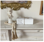 Decorative white faux books with "With God All Things Are Possible" quote, accompanied by a farmhouse bead garland with tassels.