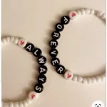 Handmade personalized beaded bracelet with heart charm, featuring customizable name or message, perfect for gifting.
