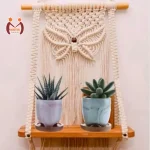 Handmade macrame wall hanging shelf with natural wood and white twiner for home decoration.