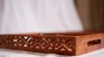 Handmade Pakistani wooden tray with intricate carvings, perfect for serving or decoration.